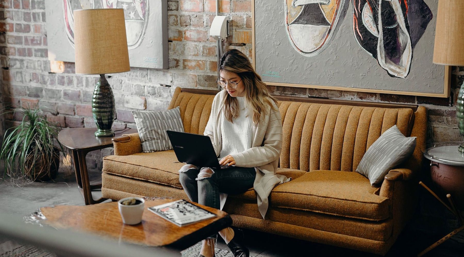 a woman sitting on a couch using a computer