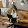 a woman sitting on a couch using a computer